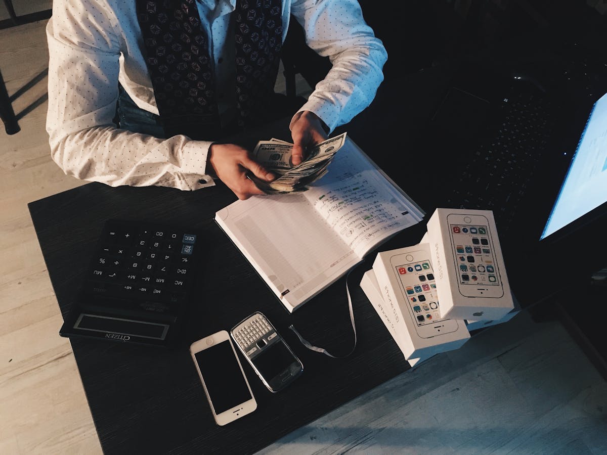 Australian small business owner reviewing bookkeeping records with a calculator and ledger
